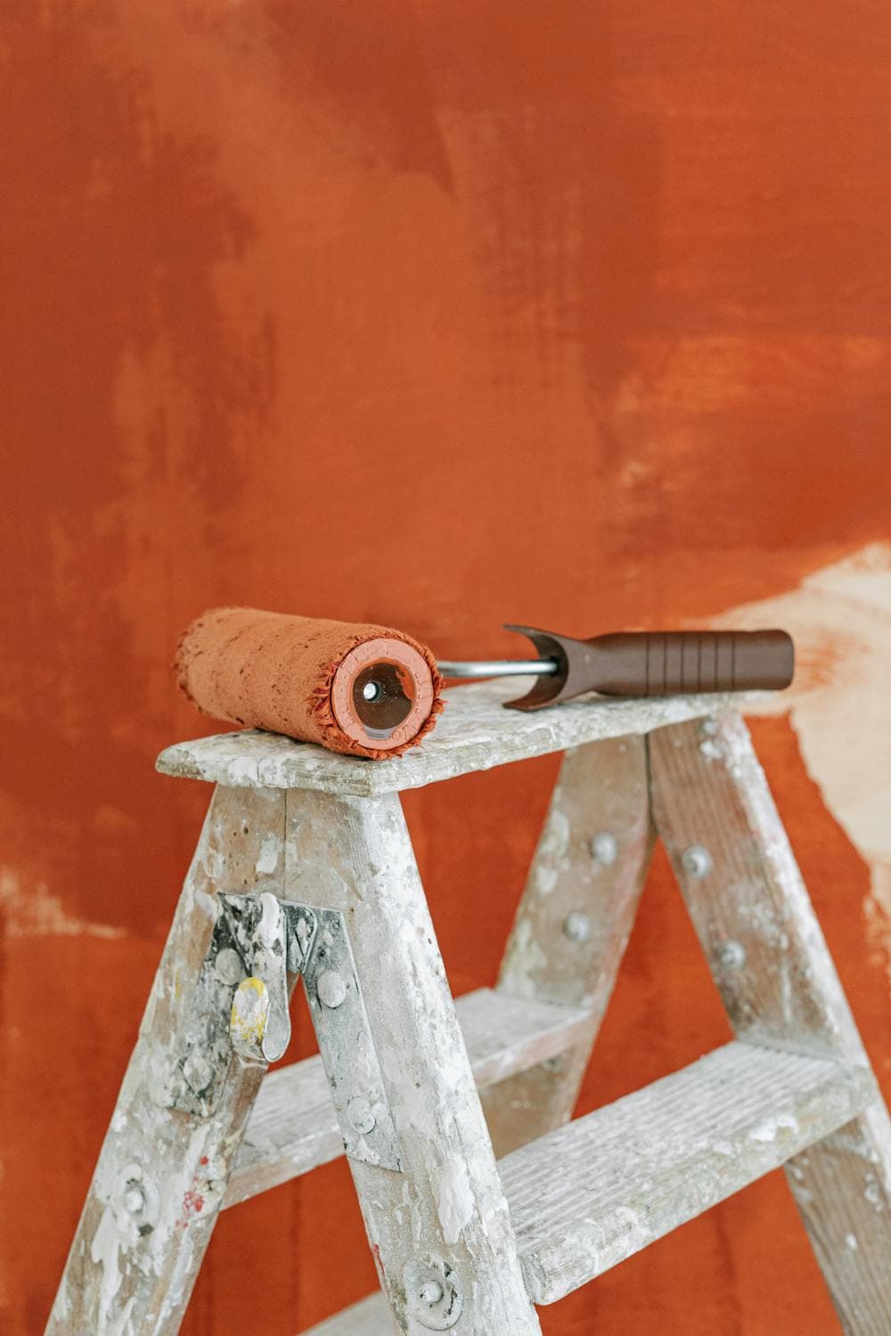 Professional interior painting with roller and ladder