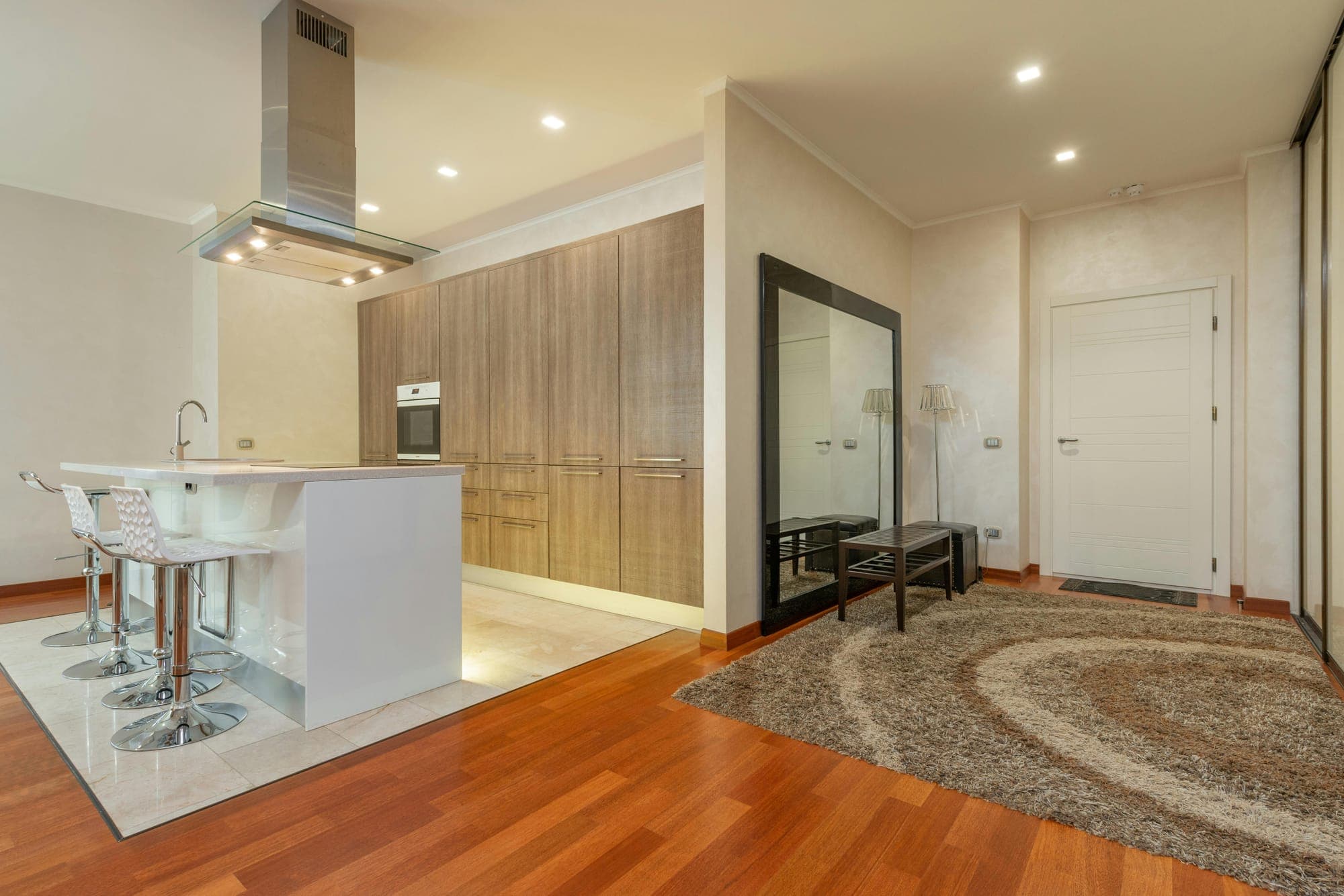 Open kitchen and entryway with warm neutral walls and wood cabinets