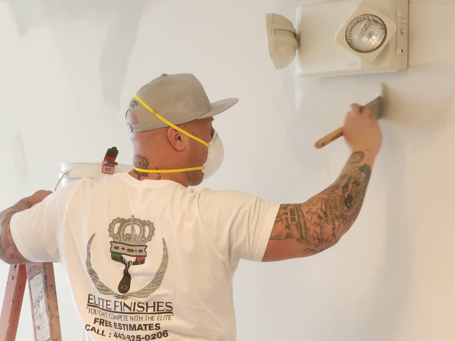 Elite Finishes painter brushing a fresh coat on an interior wall in a Baltimore home