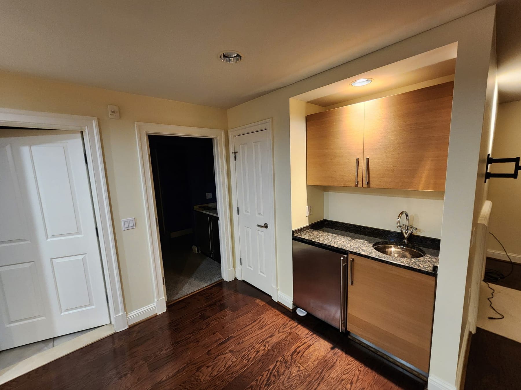 Finished wet bar with wood cabinets, granite counter and fresh trim in a Baltimore area home